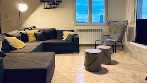 A modern living room with a sectional sofa, a chair, two round side tables, and a large window with a view of the sky. - Beautiful villa with private pool and exceptional sea views. VT-513857-A (Calpe)