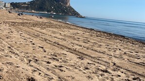 A beach with a prominent rock formation, sandy terrain, and a clear blue sky. - Beautiful villa with private pool and exceptional sea views. VT-513857-A (Calpe)