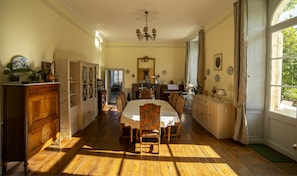 A dining room with a wooden table, chairs, and a chandelier.