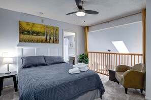 Relax in this inviting room with a large bed, bedside table, and balcony offering a view of the outdoors.