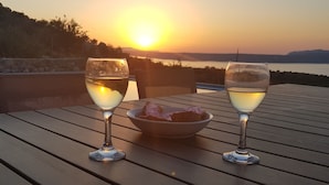 Two glasses of white wine on a wooden table with a bowl of bread and a scenic sunset view. - Villa Cape Town design and tranquility in an enchanting (kokkino chorio)