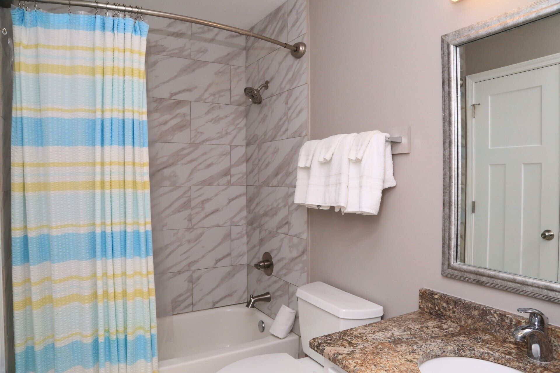 A bathroom with a shower, toilet, and sink.