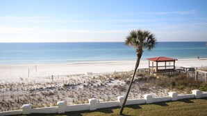 A beach with a wooden gazebo and a palm tree. - El Matador 332 -  FREE TICKETS!! Your stay includes free tickets to many area attractions! (Fort Walton Beach)