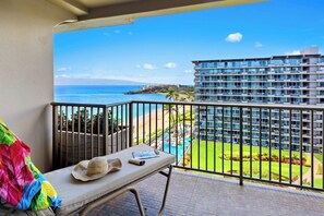 Un balcon avec vue sur l’océan, une piscine et un bâtiment d’hôtel.