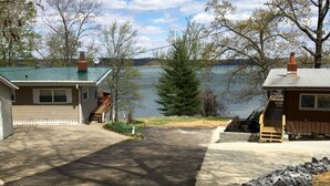Il s’agit d’une propriété résidentielle dotée d’une allée menant à une maison avec un toit végétalisé, une terrasse en bois et une vue sur un lac.