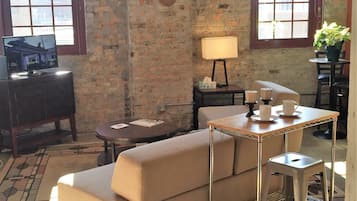 Relax in this inviting living room with a sofa, round table, and potted plant.