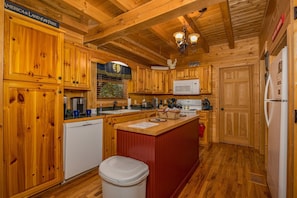 Enjoy cooking in this well-equipped kitchen with a central island, microwave, sink, and various appliances.