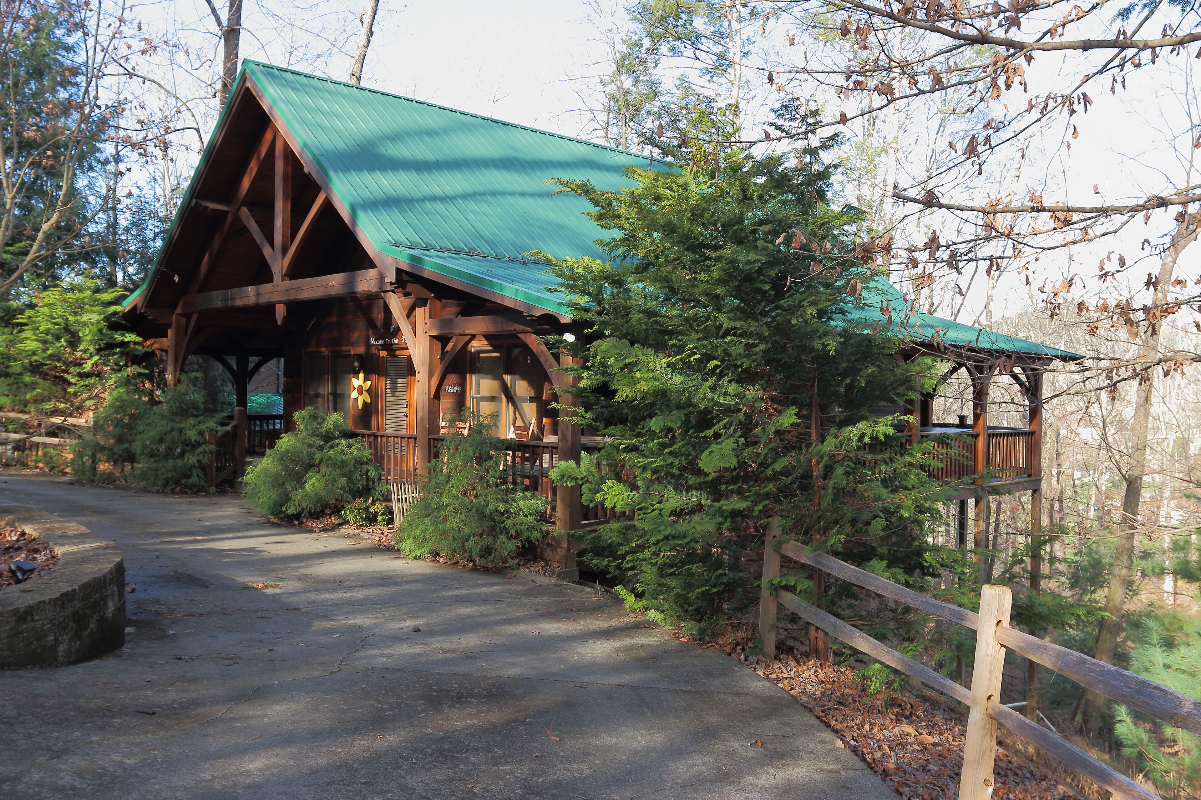 Un chalet doté d’un toit végétalisé, d’une structure en bois et d’une véranda couverte.