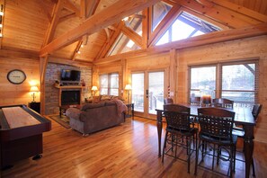 Relax by the fireplace, enjoy meals at the dining table, or play a game on the pool table in this spacious room with high ceilings.