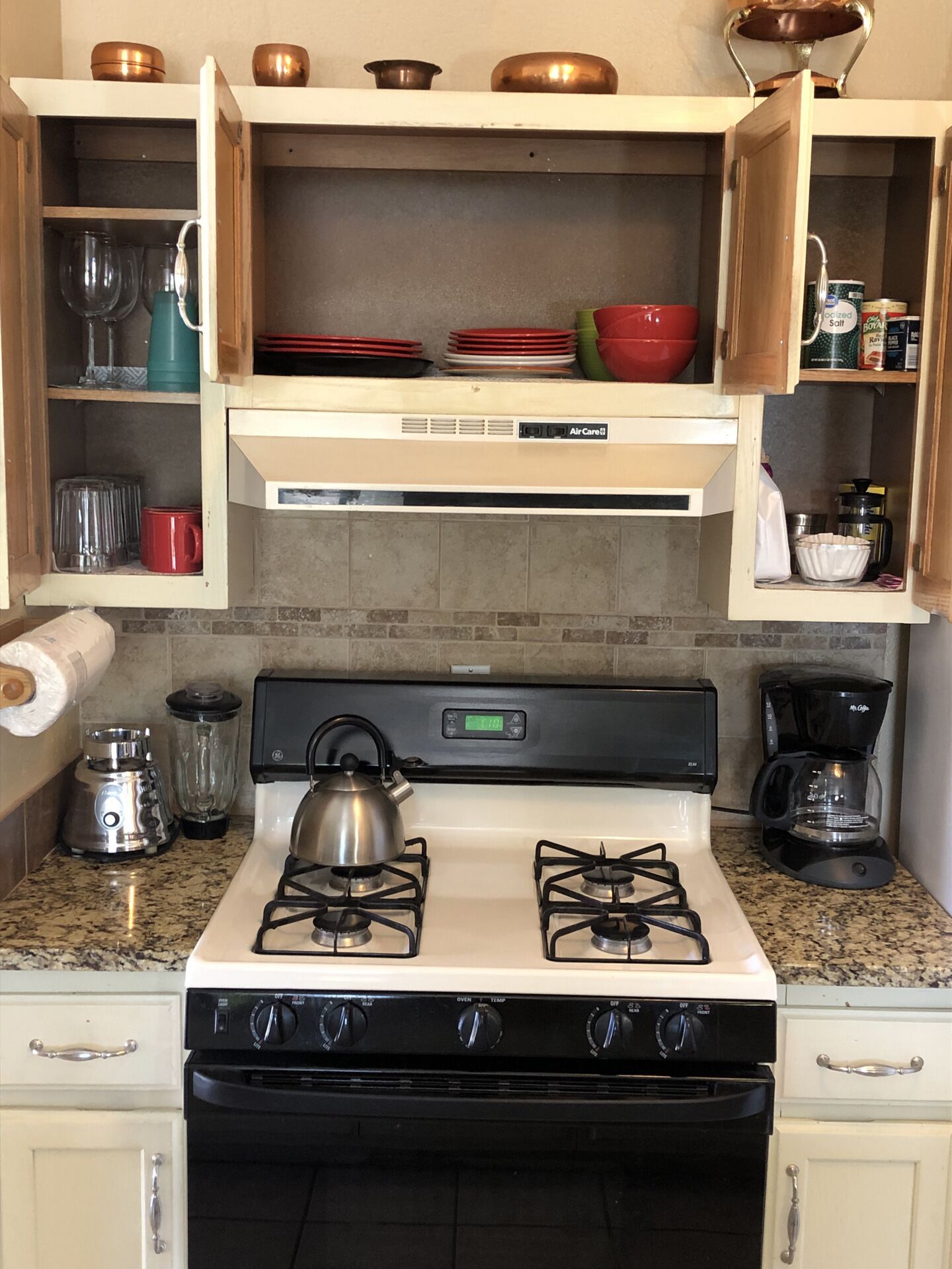 A kitchen with a stove, gas range, and various kitchen appliances.