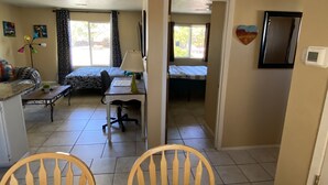 Un grand espace de vie comprenant une table à manger, des chaises, un canapé et un lit.