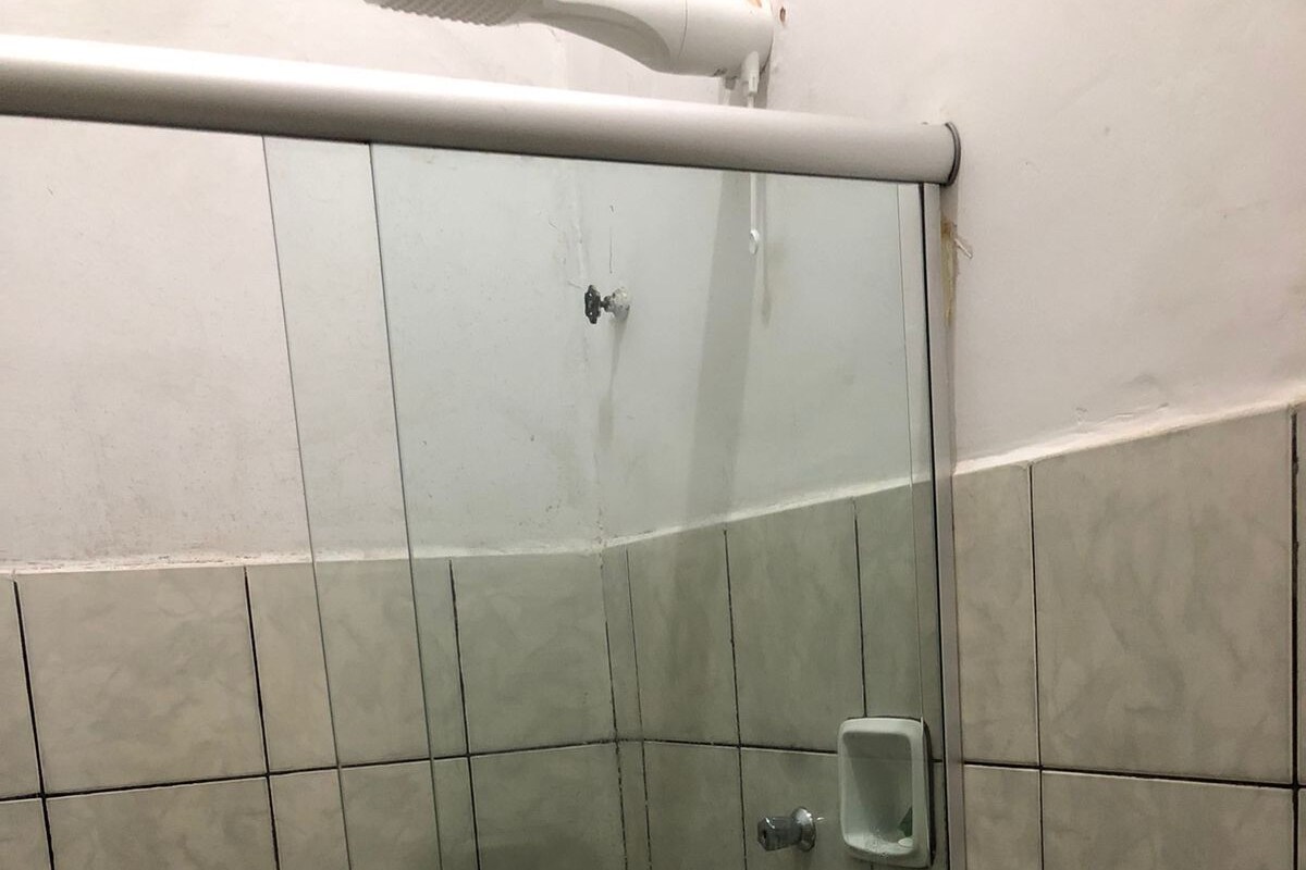 A bathroom with a glass shower enclosure, a toilet, and a small soap dish.