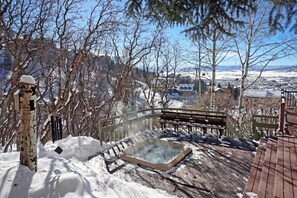 A snow-covered deck with a hot tub, wooden benches, and a view of a town in the background. - >100 Yards to Slopes + Private Hot Tub w/ Gondola Views EZCancel (Steamboat Springs)