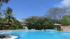 A clear blue pool surrounded by palm trees and lounge chairs. - Gringo Paradise, a perfect Costa Rican get away! (Potrero)