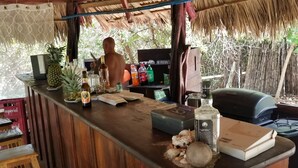 A rustic bar area with wooden furniture, a computer, and various beverages. - Gringo Paradise, a perfect Costa Rican get away! (Potrero)