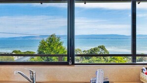 A bathroom with a large window, a sink, and a towel rack. - Zenith - Freycinet Holiday Houses (Coles Bay)