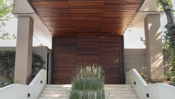 A staircase leading to a wooden door with a planter in front. - Capitalia | Near to ABC Hospital with Gym/Parking (Ciudad de México)