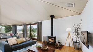A living room with a sofa, coffee table, and a fireplace. - Abercorn - one of Stayz’s 2025 Holiday Homes of the Year (Buckaroo)