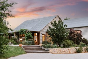 A house with a sloped roof, a stone retaining wall, and a well-maintained garden with steps leading to the entrance. - Abercorn - one of Stayz’s 2025 Holiday Homes of the Year (Buckaroo)
