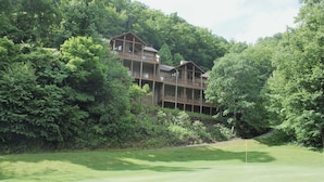 A multi-story wooden building surrounded by dense forest, likely a lodge or resort. - Resort Condo with Poker Table, 6 Beds and 1 dog permitted! (Whittier)