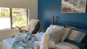 A bedroom with a bed, a chair, a window, and a painting on the wall. - Private , tranquil cosy retreat with massage chair-l (Melbourne)