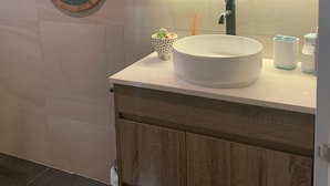 A bathroom with a round white sink, a hanging wooden tree decoration, and a small cactus plant on the counter. - Private , tranquil cosy retreat with massage chair-l (Melbourne)
