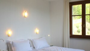 A bedroom with a bed, two bedside tables, and a window with curtains. - Lovely greenery detached house with inground private swimming pool.  Large garde (Tresana)