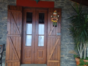 A wooden double door with a decorative wreath above it.