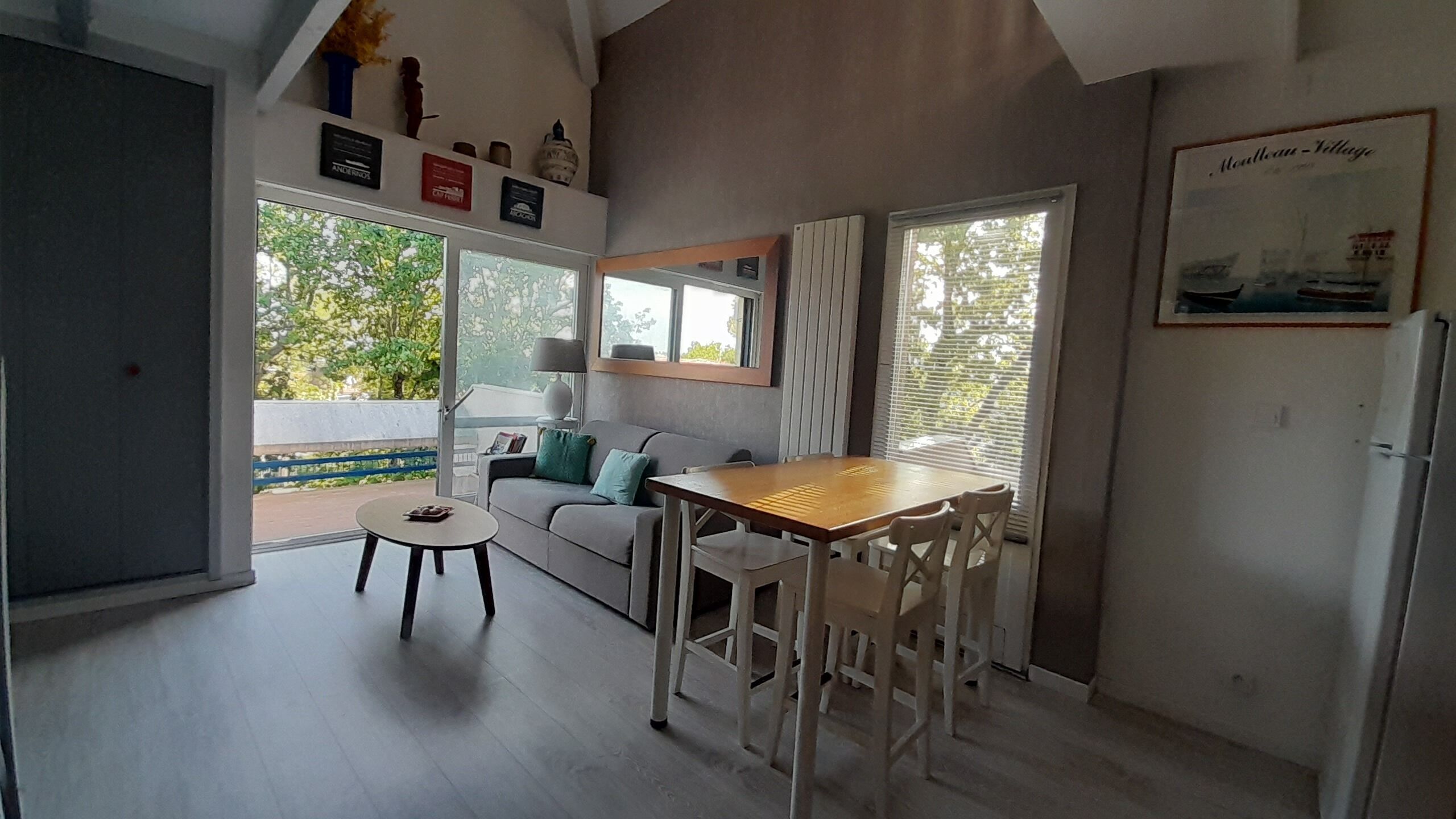 Une cuisine moderne avec une table à manger, des chaises, un canapé et un réfrigérateur.
