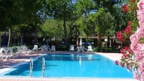 Una piscina rettangolare con acqua cristallina, circondata da un vialetto in mattoni e confortevoli lettini da spiaggia.