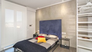 A modern bedroom with a large bed, a bedside table, a wardrobe, and a view through a glass door. - Mediceo 42 - Comfort Double Room with Balcony (Pisa)