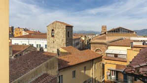 A historic town with traditional architecture, including a prominent tower and buildings with terracotta roofs. - Mediceo 42 - Comfort Double Room with Balcony (Pisa)