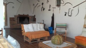 Ein gemütlicher Raum mit einem Bett, einem Sessel, einem Tisch mit einer Kürbis und einem Kamin.