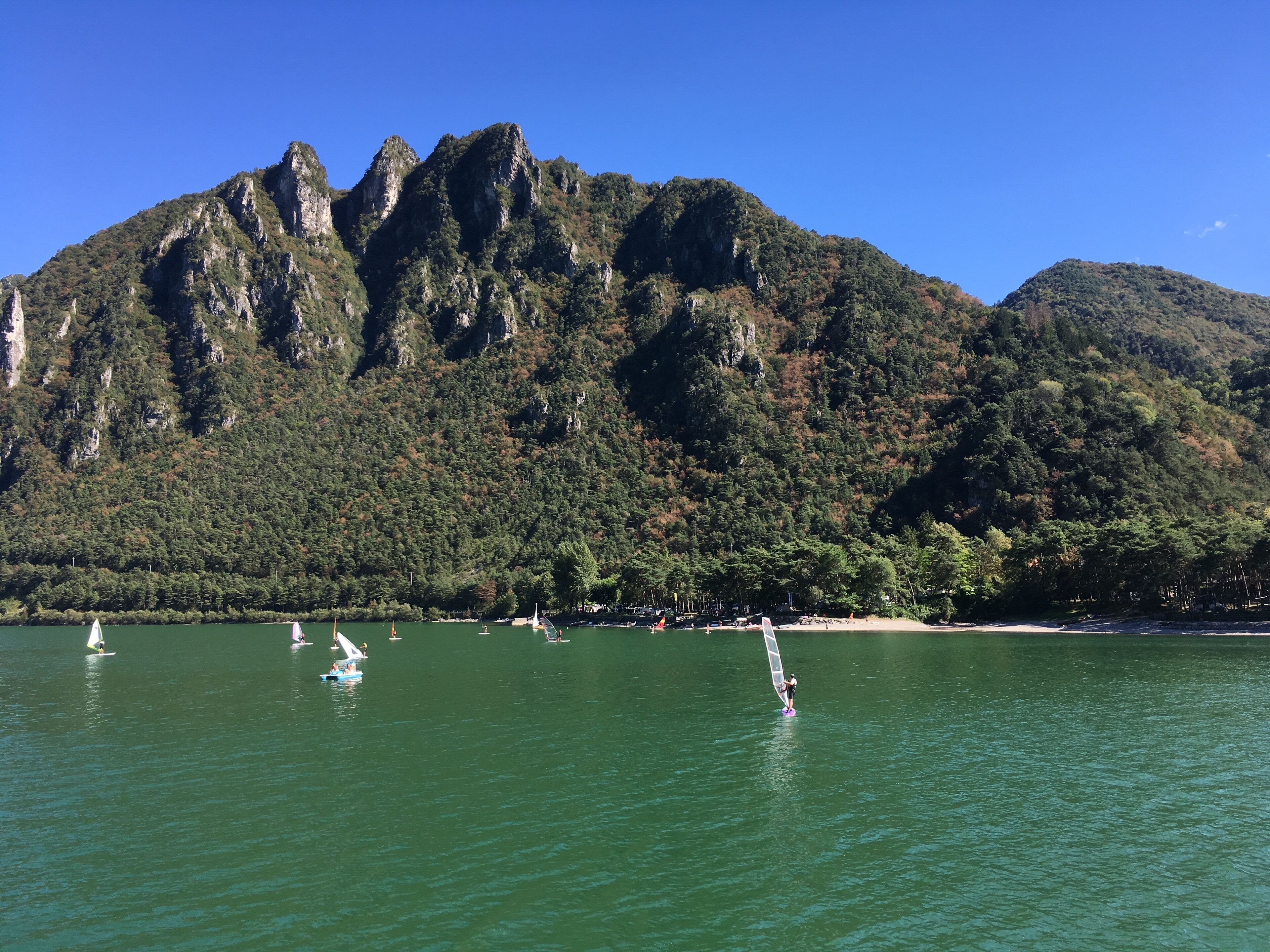 Un paisaje costero con montañas al fondo.