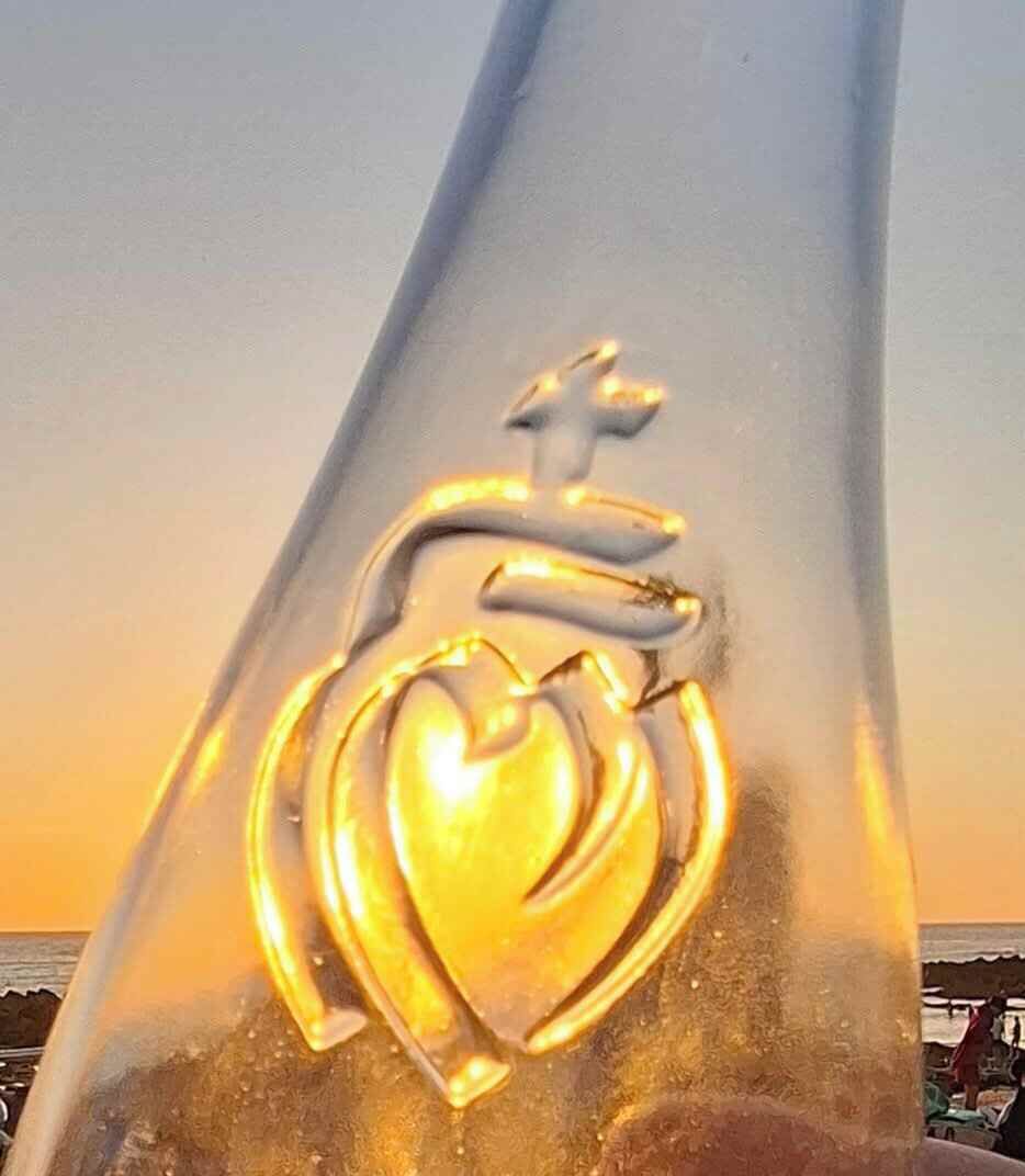 A clear view of a glass structure with a heart and cross emblem.