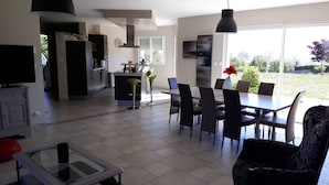 Una cucina moderna con zona pranzo, televisione e un'ampia finestra.