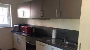 Una cocina con microondas, tostadora, horno y lavaplatos.