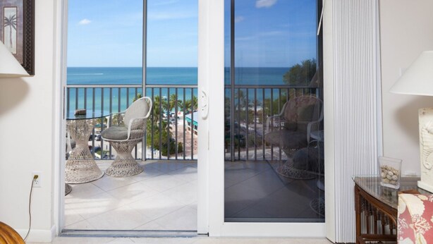 A balcony with wicker chairs and a view of the ocean. - Bonita Beach 5500 - 1906 (Bonita Springs)