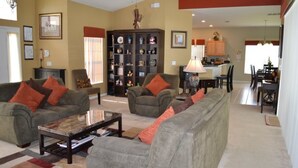 A spacious living room with a sofa set, a coffee table, and a bookshelf.