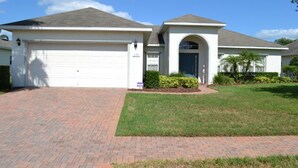 A single-story house with a garage, a covered entryway, and a well-maintained lawn.