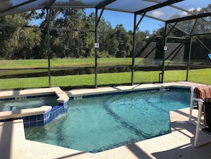 A swimming pool with a glass enclosure, a hot tub, and a lounge chair. - Sandy Ridge 160 (Davenport)