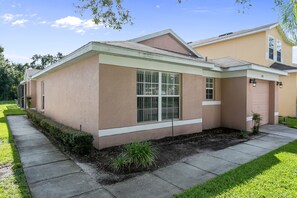 A single-story house with a beige exterior, a front porch, and a garage. - Sandy Ridge 160 (Davenport)