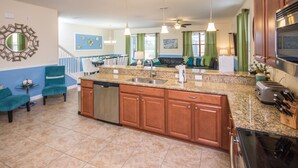 A spacious kitchen with granite countertops, wooden cabinets, and stainless steel appliances. - Providence 2401 (Davenport)