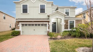 A two-story house with a garage, a front porch, and a well-maintained lawn. - Providence 2401 (Davenport)