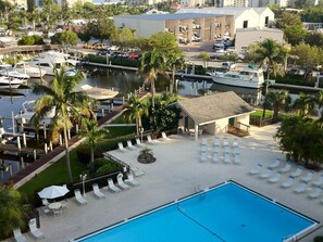 A marina with boats, a swimming pool, and a covered area with lounge chairs.