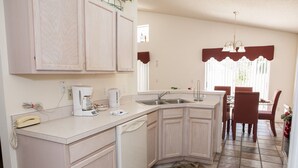 A compact kitchen with a dishwasher, a coffee maker, and a telephone. - Westridge 1007 (Davenport)
