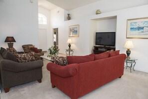 A living room with two sofas, a TV, and a small table with lamps. - Westridge 1007 (Davenport)