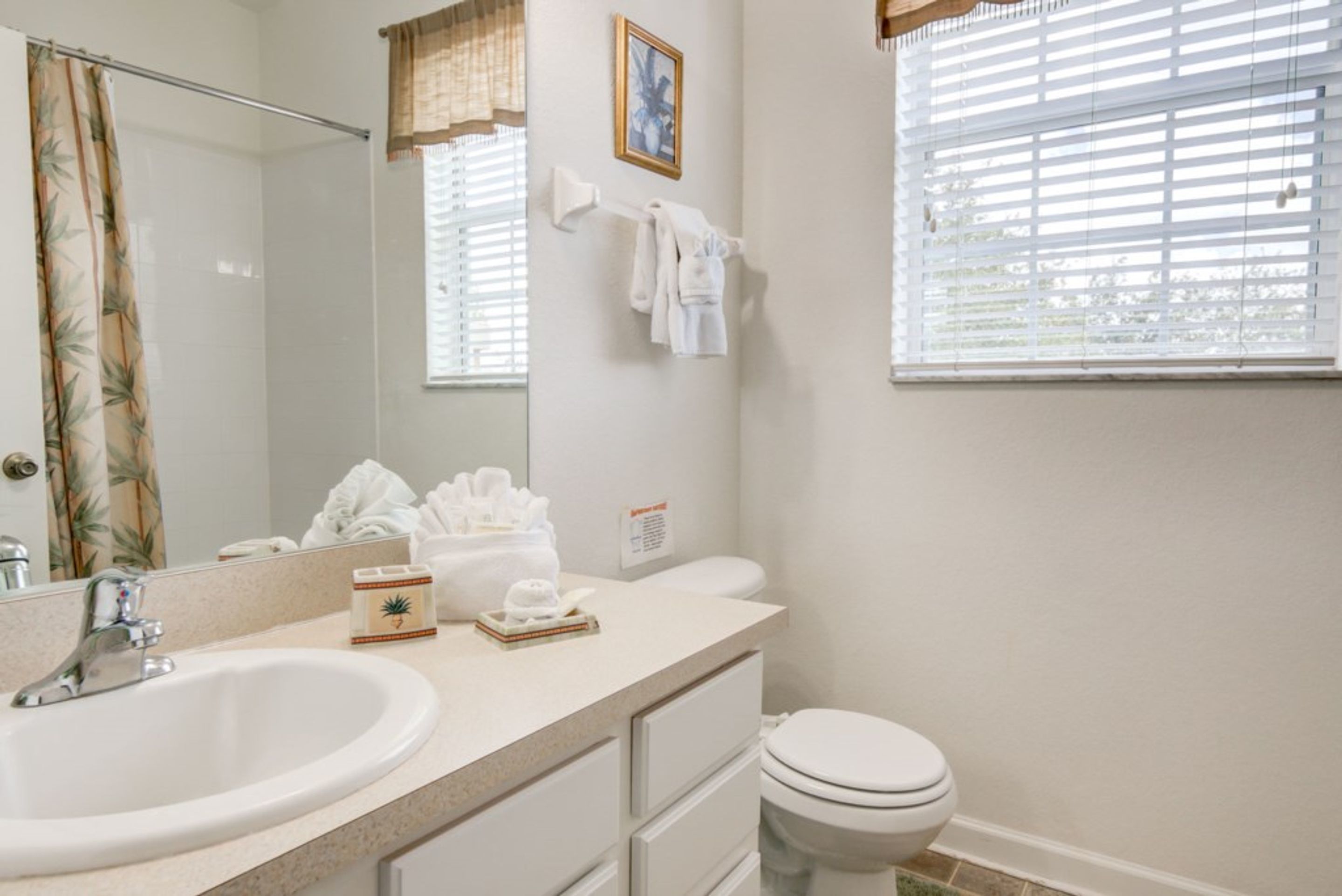 A bathroom with a sink, toilet, and a towel rack with towels.