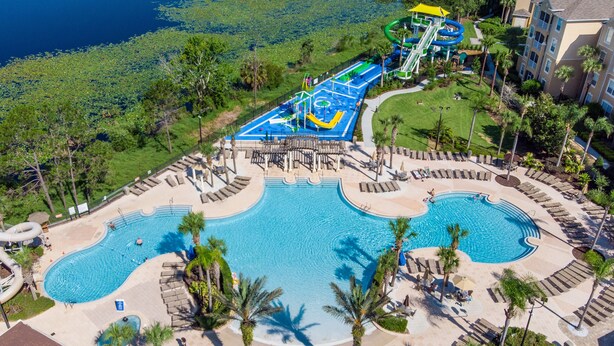 A resort with a large pool, a water park, and a well-maintained lawn area. - Windsor Hills 7675 - 303 (Kissimmee)