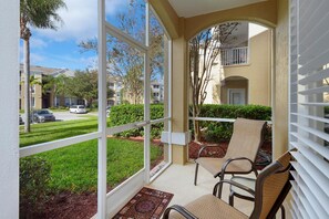 A balcony with two chairs, a view of a residential area, and a door. - Windsor Palms 2305 - 101 (Kissimmee)